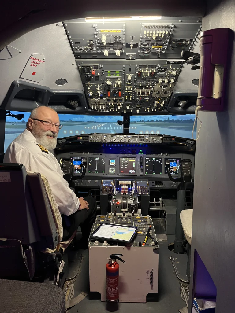 Friendly pilot welcoming you to the cockpit of a 737 simulator